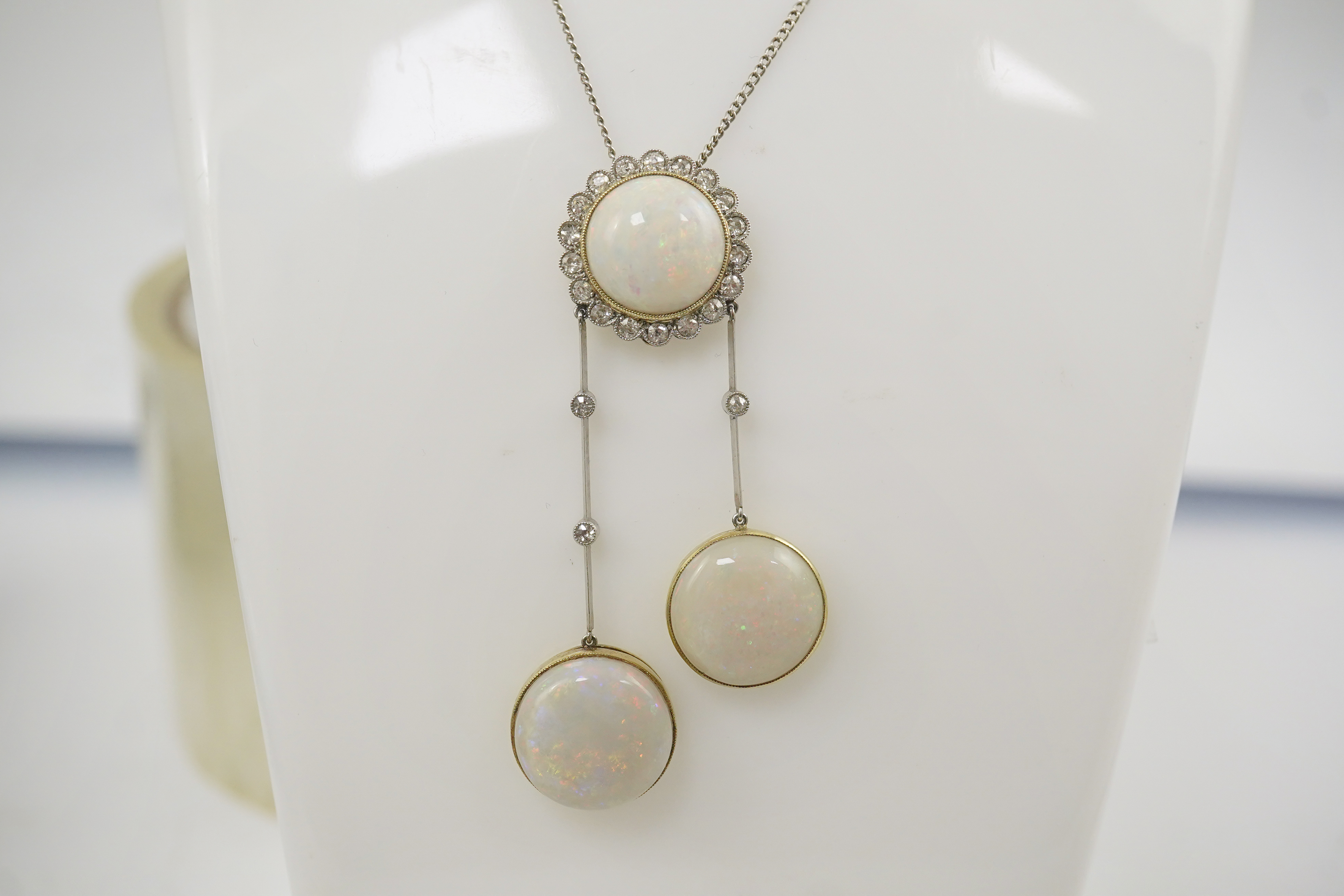 A Belle Epoque platinum and gold, white opal and millegrain set diamond double drop pendant necklace, the chain by Child and Child